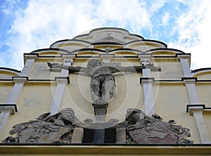 Front face of historic building with crucified Jesus Christ statue