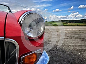 Front headlamp of red MGB raodster