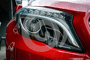 Front highlight of red Mercedes GLA 200 details on a rainy day photo