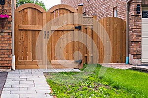 Front of a house with wooden gate. Backyard with wooden new gates. Gate, fence, home entrance