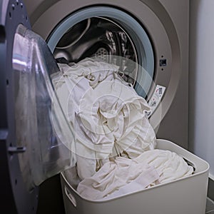 A front load washer with a pile of white clothings. photo