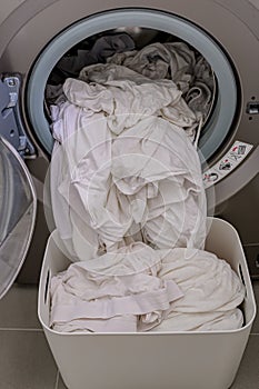 A front load washer with a pile of white clothings. photo