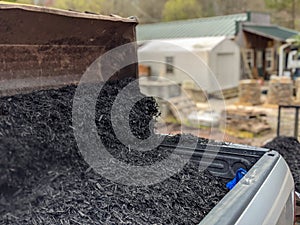 Front loader filling pickup and trailer with black mulch