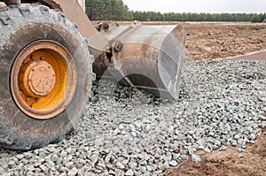 The front loader flattens the rubble on the road. Roadworks