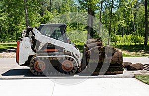 Front loader and a pallet with rolls of sod grass for installation photo