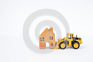 Front loader truck moving wooden miniature house isolate on white background