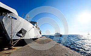 Front loading ferry boat moored with lifted bow at pier.