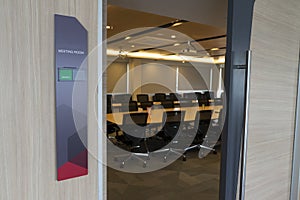 Front of meeting room with a tag status and fire alarm notification , wooden table , sunlight from windows