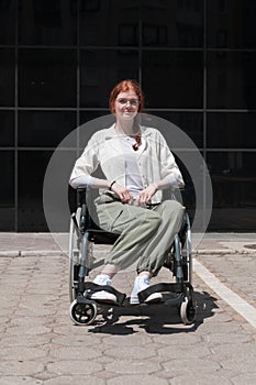 In front of a modern corporate building, a young woman sitting in a wheelchair confidently, symbolizing empowerment