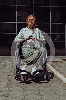 In front of a modern corporate building, a young woman sitting in a wheelchair confidently, symbolizing empowerment