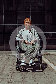 In front of a modern corporate building, a young woman sitting in a wheelchair confidently, symbolizing empowerment