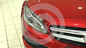 The front of the new red car. Headlight of the new machine. View of row new car at new car showroom.