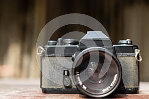 In front of an old black film camera with a red towel