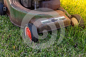 Front of an old lawn mower cutting grass