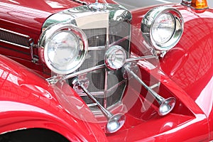 Front of old red car close up with round headlights