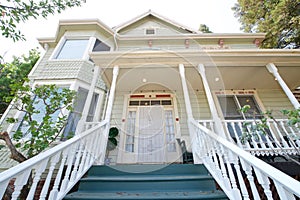 Front of old Victorian home, looking up from base of stairs to door