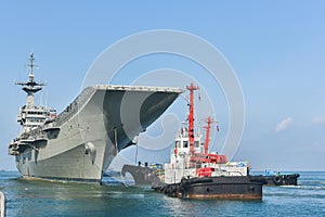 Front old warships from war in shipyard Tug boat helps drag after maintenance