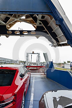 Front open door of passenger freight cargo ferry boat vessel ship with loaded cars and vehicles. Sea transportation