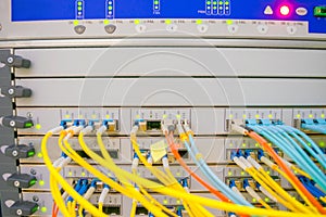Front panel of the central router with a set of optical links is in the server room of the data center. Optical fiber wires are