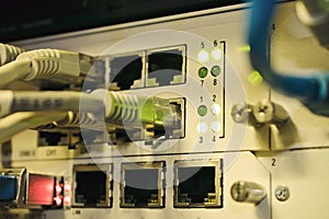 Front panel of an old internet switch. Network interfaces and cables are interconnected. Communication wires connect to equipment
