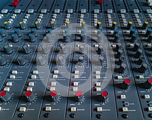 Front panel of old music radio console with colorful potentiometers and sliders