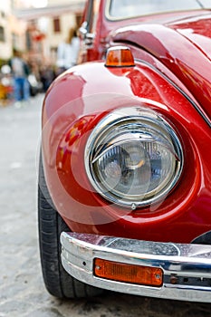 Front part of a classic car with a round headlights. Fancy vintage retro car attracting the attention of visitors and amateurs of