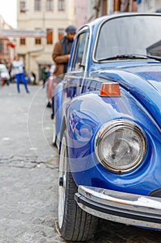 Front part of a classic car with a round headlights. Fancy vintage retro car attracting the attention of visitors and amateurs of