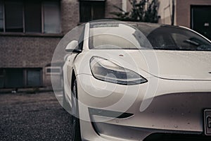 Front part of a white car in the rain.