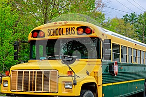 Front part of yellow school bus children educational transport with signs in the parking
