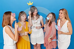 Front photo of a group of joyful women to have gender reveals envent, isolated blue background.