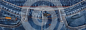 Front pockets, waist area, zipper, and its button of dark blue jeans. Close up shot. Clothing concept