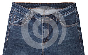 Front pockets, waist area, zipper, and its button of dark blue jeans isolated on white background. Close up shot. Clothing concept