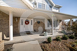 Front porch exterior of a two storey house with bricks and bush at the front yard