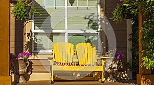 Front porch with furniture and potted plants. Rustic, country style front porch with Adirondack chairs and flowers