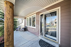 Front porch of a house with engineered wood siding wall and log column post