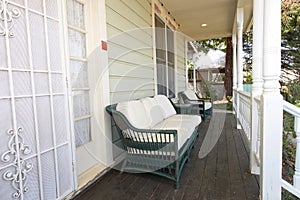 Front porch on old victorian home with wicker chairs