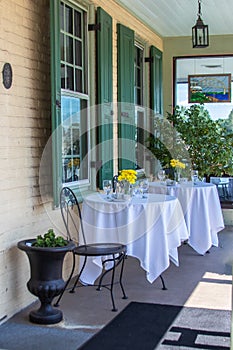 Front porch set for lunch with yellow flowers.