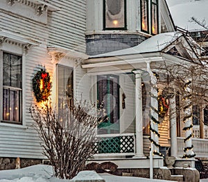 Front porch of White New England clapboard house fully decorated to welcome the holiday season