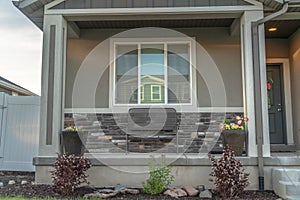 Front porch and yard of a family home with concrete outdoor stairs and gray door