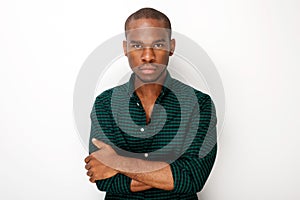 Front of handsome young black man against isolated white background with arms crossed