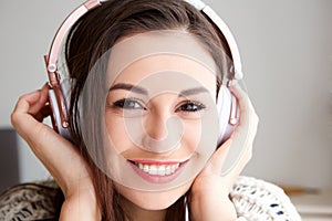 Front portrait of happy young woman listening to music with headphones