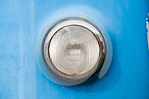 Front round chrome headlight of a vintage car