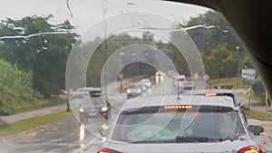 Front screen and rain drops on car in traffic jam, transport