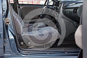 Front seats inside the car: the driver and passenger, tied with gray material, old interior design