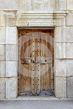 Front shoot of ancient civilization made wooden door on historical stone building