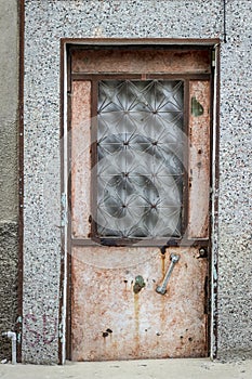 Front shoot of open brown colored metal door with traditional turkish pattern by stone wall