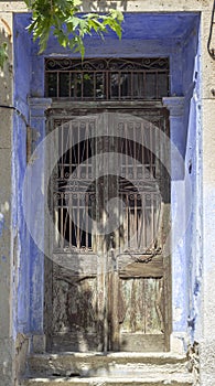 Front shot of traditional ornamented pale blue metal door stone covered frame