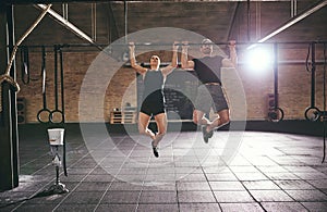 Front shot of two sportsmen doing pull-ups