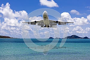 Front side view commercial passenger aircraft or cargo transportation airplane flying on blue sky over sea and spread the wheel