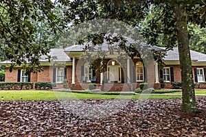 A front side view of an updated spacious red brick ranch traditional house home with off white columns and brick front steps with